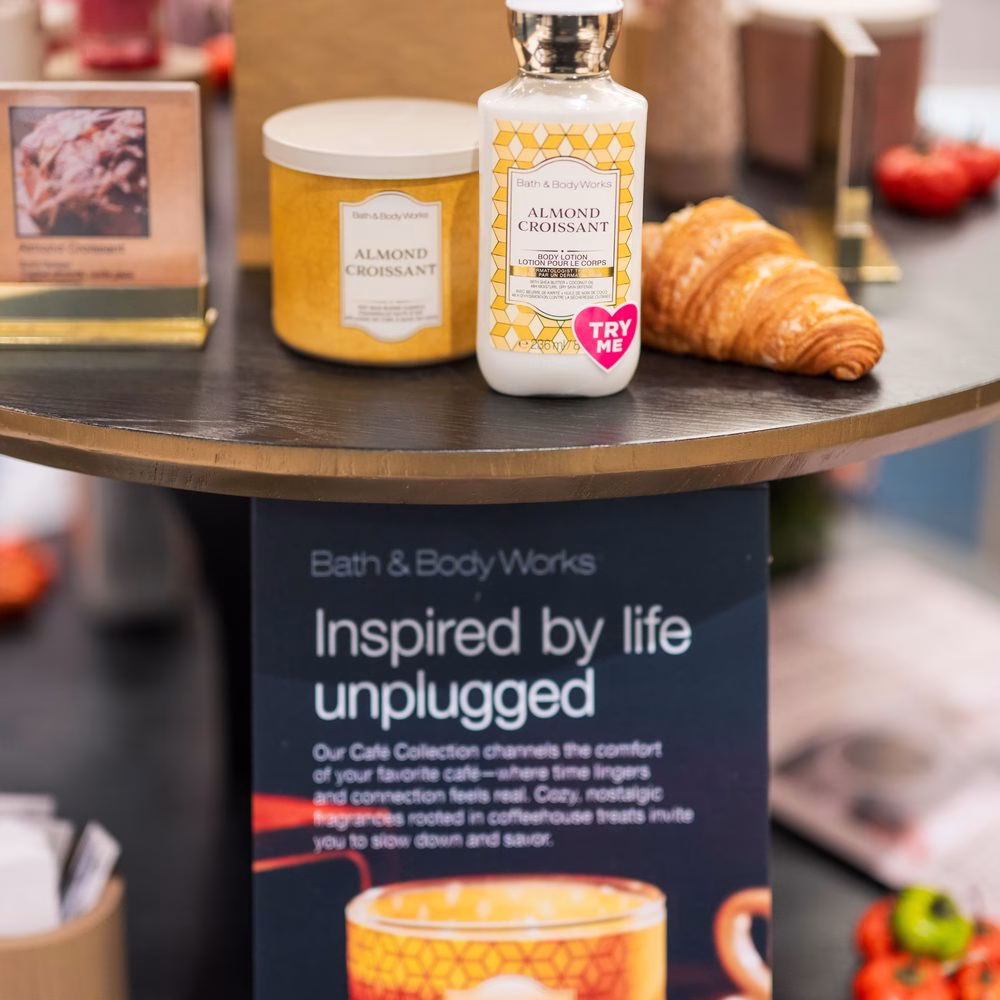 Bath & Body Works Almond Croissant candle and body lotion beside a croissant